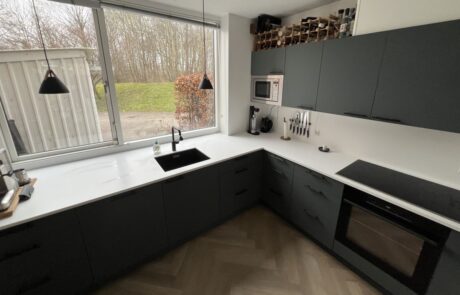 køkkenfornyelse det færdige resultat med corian bordplade og fronter i fenix laminat